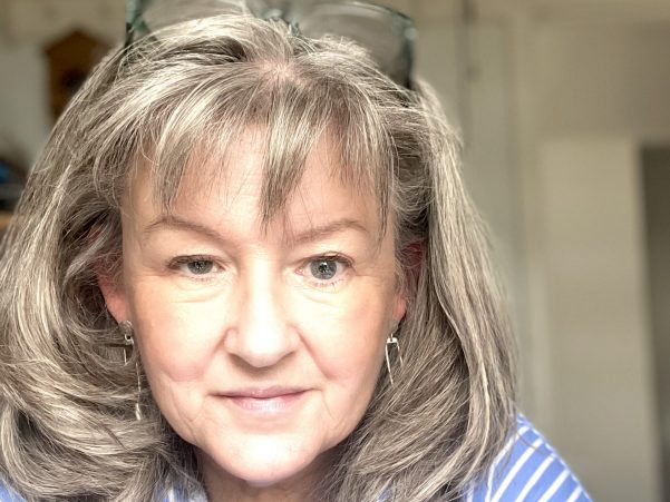 This is a picture of a grey haired women wearing and blue and white striped shirt